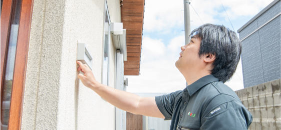 外壁をチェックしている男性スタッフ