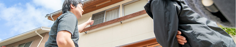 住宅を指差してお客様にご説明している様子