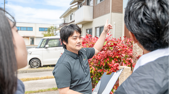 住宅の外でお客様と家の様子を確認している様子